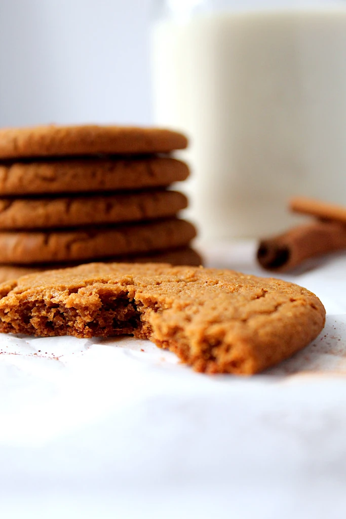 A broken cookie displays the texture inside of the cookie. Chewy, spicy, buttery and delicious.