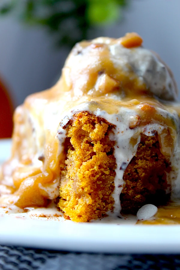 A closeup of the rich crumb texture of the cake, melting vanilla ice cream, and chopped pecans dripping down a freshly cut Maple-Butter Pumpkin Snack Cake.