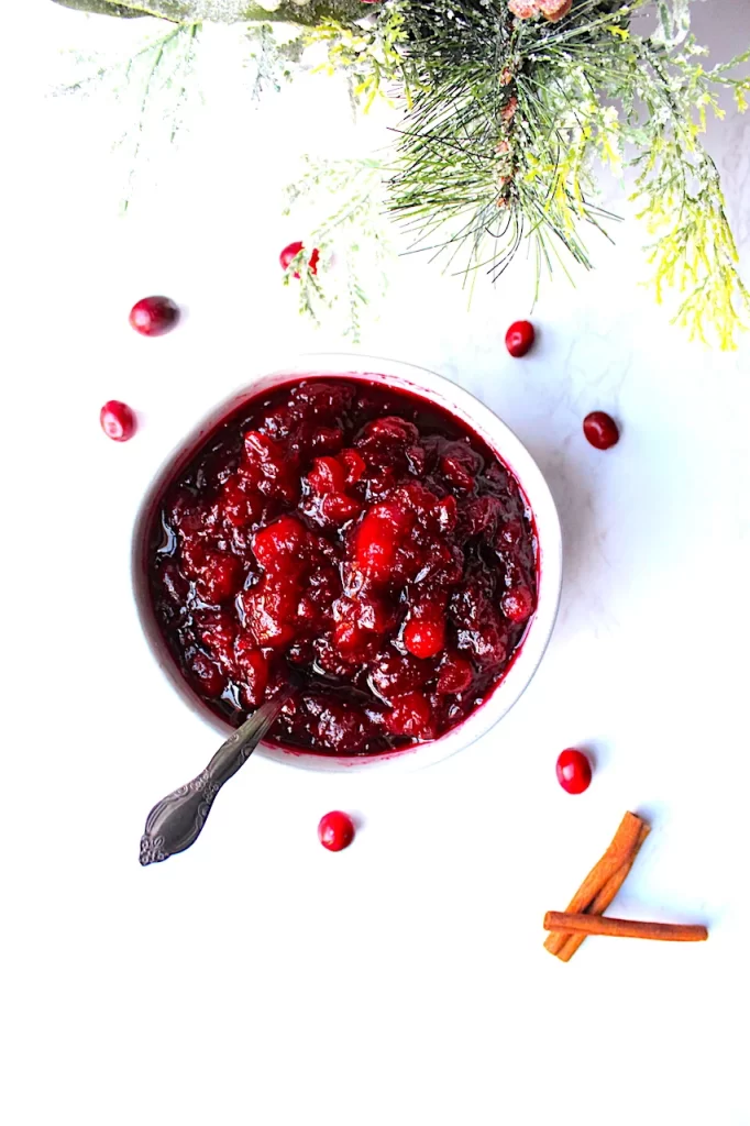 Sweet, Tart, Brilliant! A strikingly white bowl holds deep red, vibrant, spiced cranberry sauce.