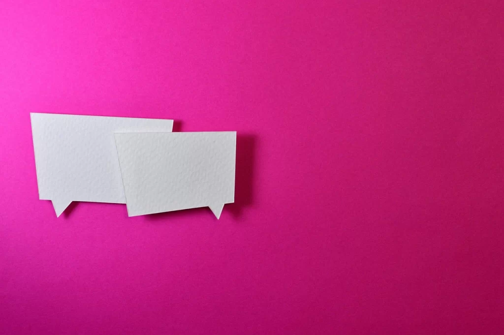 A deep pink backdrop is shown with a paper conversation shape.