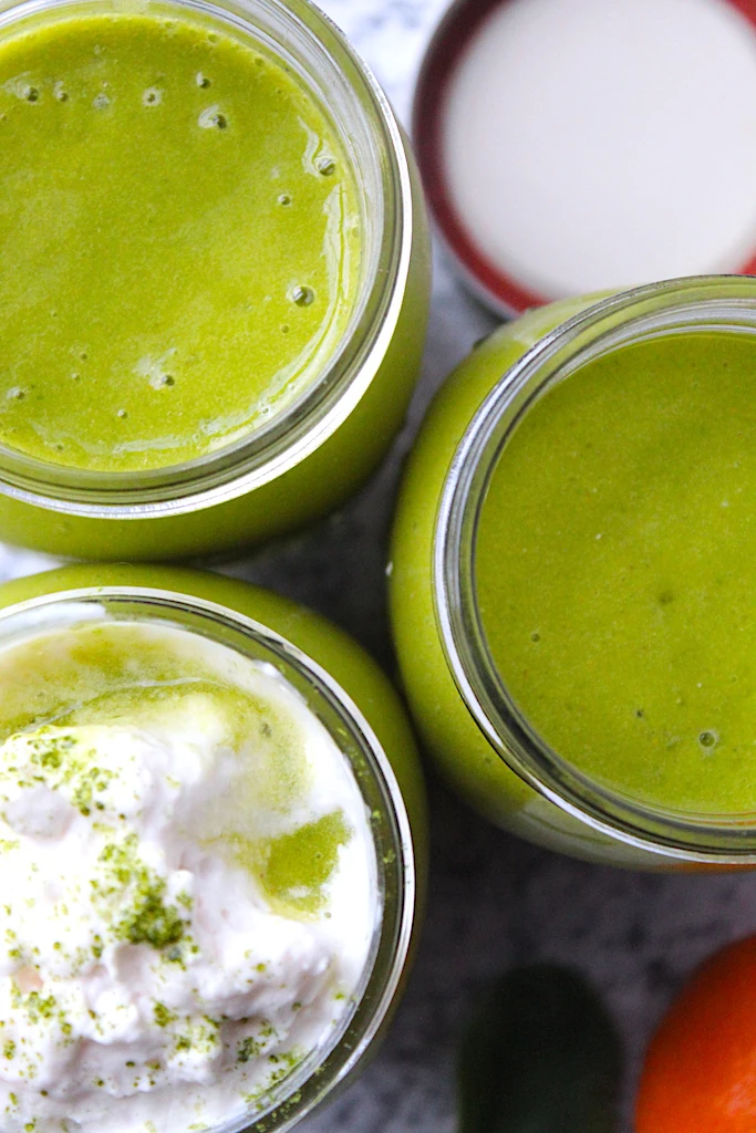 Green mason jars are filled with beautiful, green smoothies.