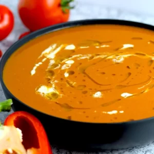 Gorgeous red roasted tomato soup, drizzled with olive oil and cream.